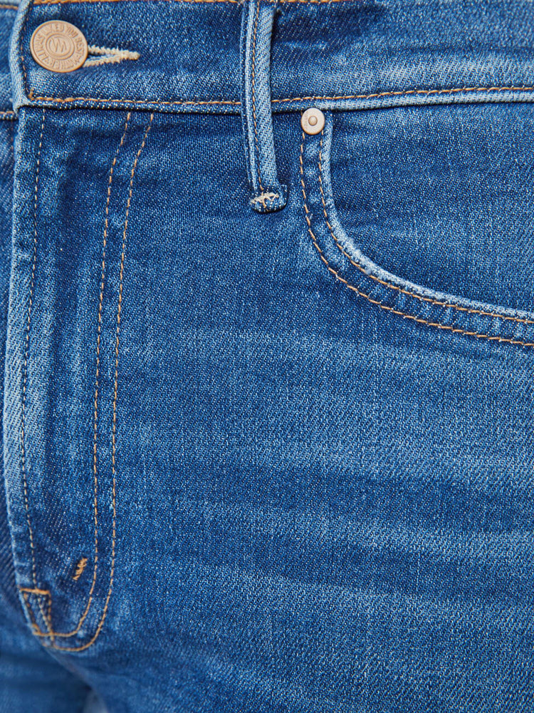 Swatch view of a woman in a medium blue wash high-rise straight leg with a 32-inch inseam and a clean hem jean.