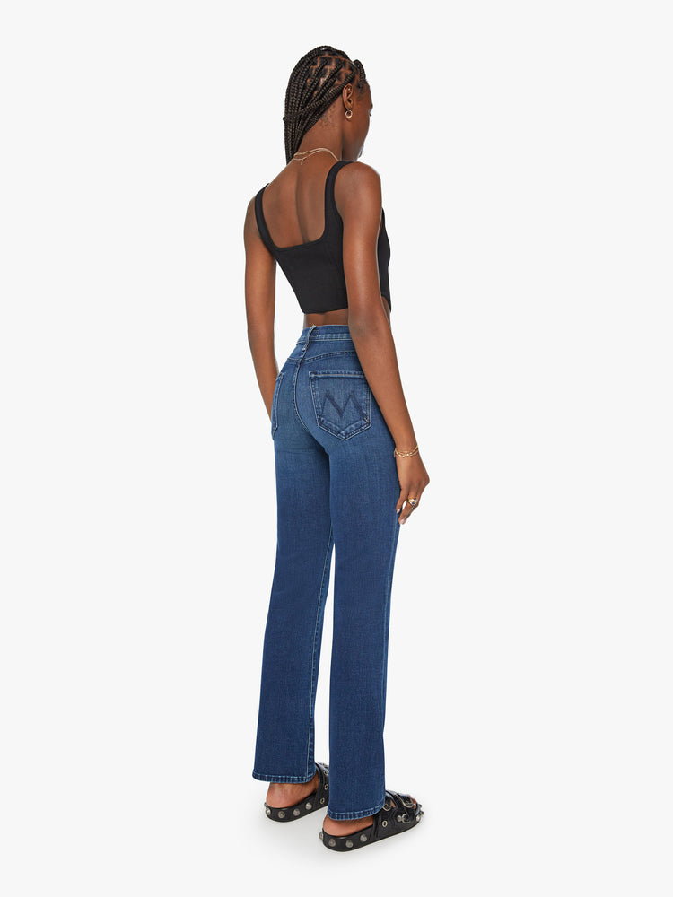Back view of a woman dark blue high-waisted bootcut with a 32-inch inseam and a clean hem.