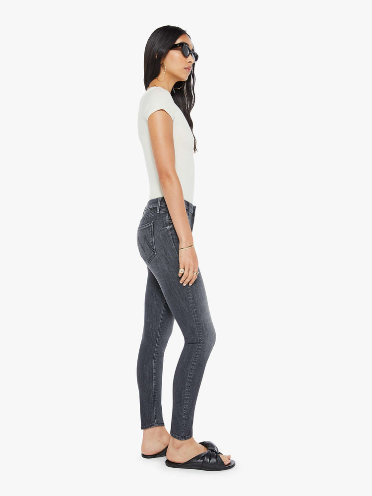 Side  view of women's dark grey mid rise skinny jean with zip fly and clean hem.