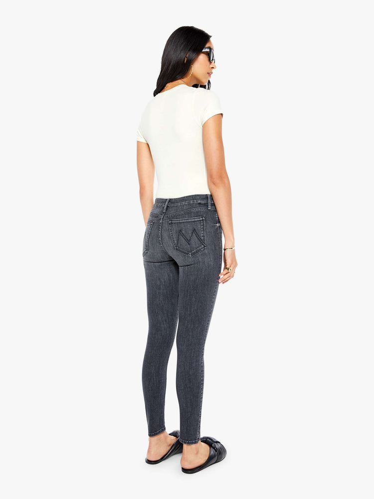 Back  view of women's dark grey mid rise skinny jean with zip fly and clean hem.