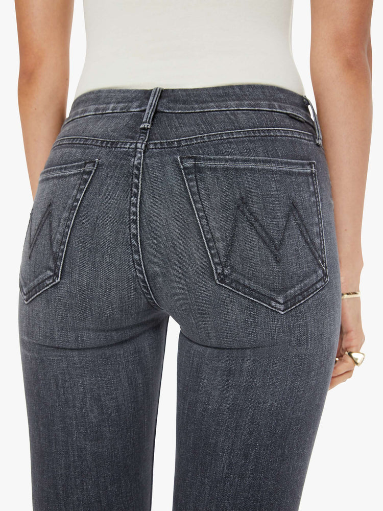 Waist  view of women's dark grey mid rise skinny jean with zip fly and clean hem.