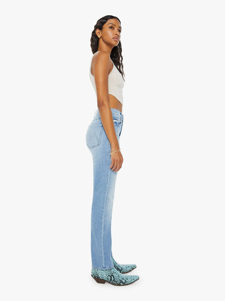 Side view of a woman in a light blue high-rise straight leg with a button fly and a 31-inch inseam.