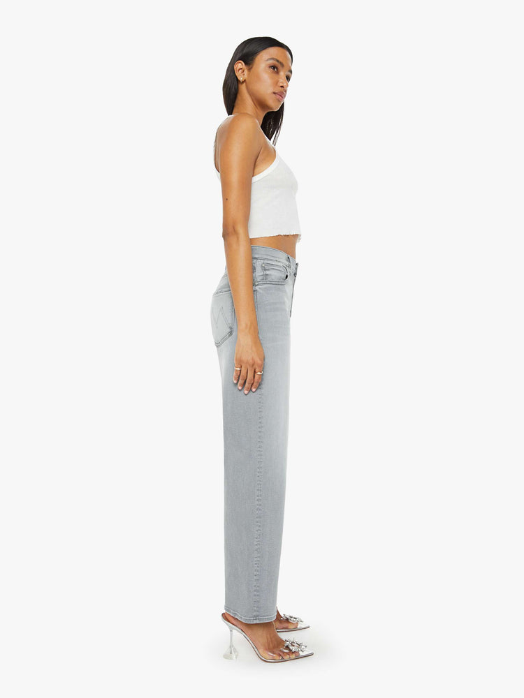 Side view of a woman in grey jean with a slouchy fit, a loose straight leg and a 28.25-inch inseam with a clean hem.