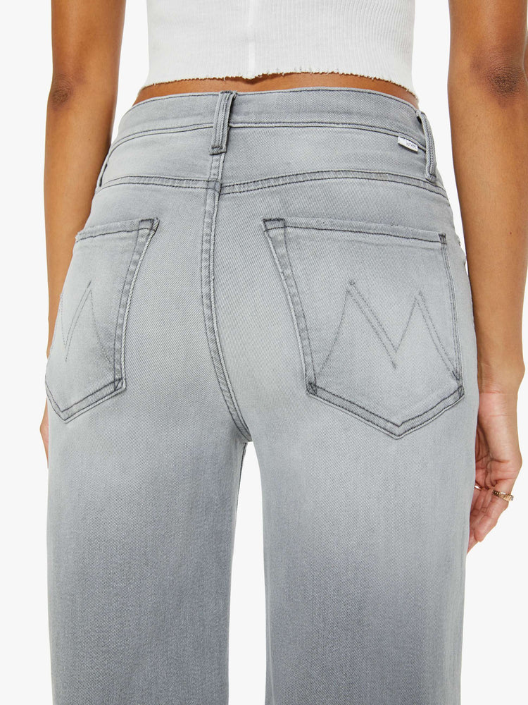 Close up view of a woman in grey jean with a slouchy fit, a loose straight leg and a 28.25-inch inseam with a clean hem.