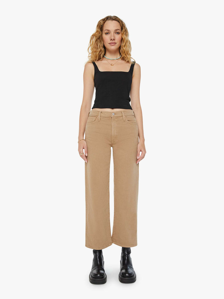 Front view of a woman in dark khaki lower rise pants with a loose straight leg and a 28.25-inch inseam with a clean hem.