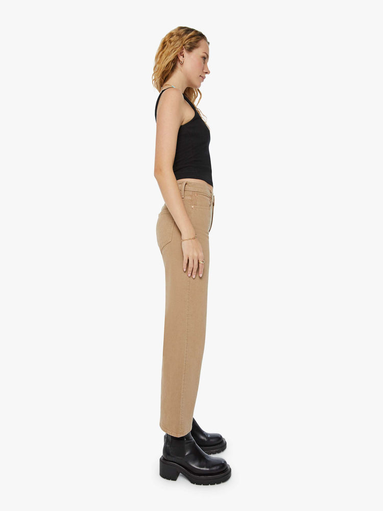 Side view of a woman in dark khaki lower rise pants with a loose straight leg and a 28.25-inch inseam with a clean hem.