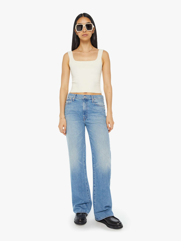 Front view of a woman in light blue denim set to sit lower on the hips with a loose straight left and clean hem.