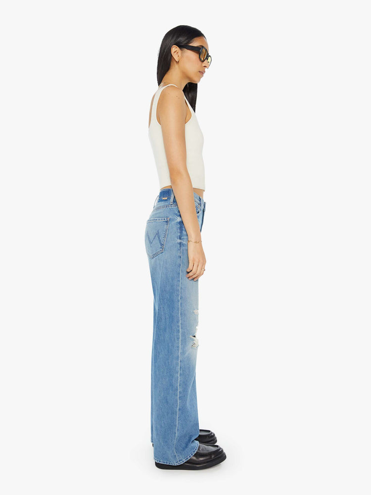 Side view of light blue jeans set to sit lower on the hips with a loose straight leg.