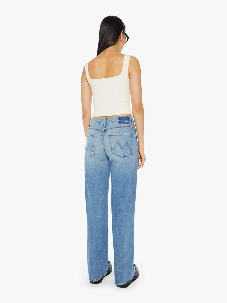 Back view of light blue jeans set to sit lower on the hips with a loose straight leg.