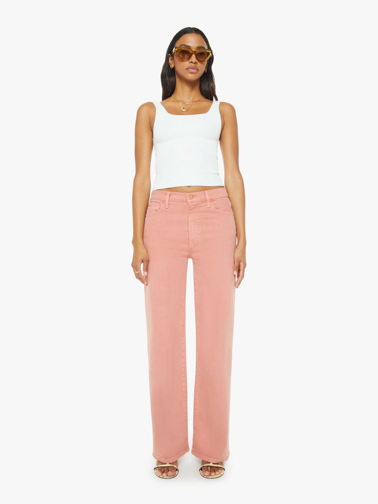 Front view of a woman in light coral pants designed to sit on the hips with a slouchy fit, a loose straight leg and a 32-inch inseam with a clean hem.