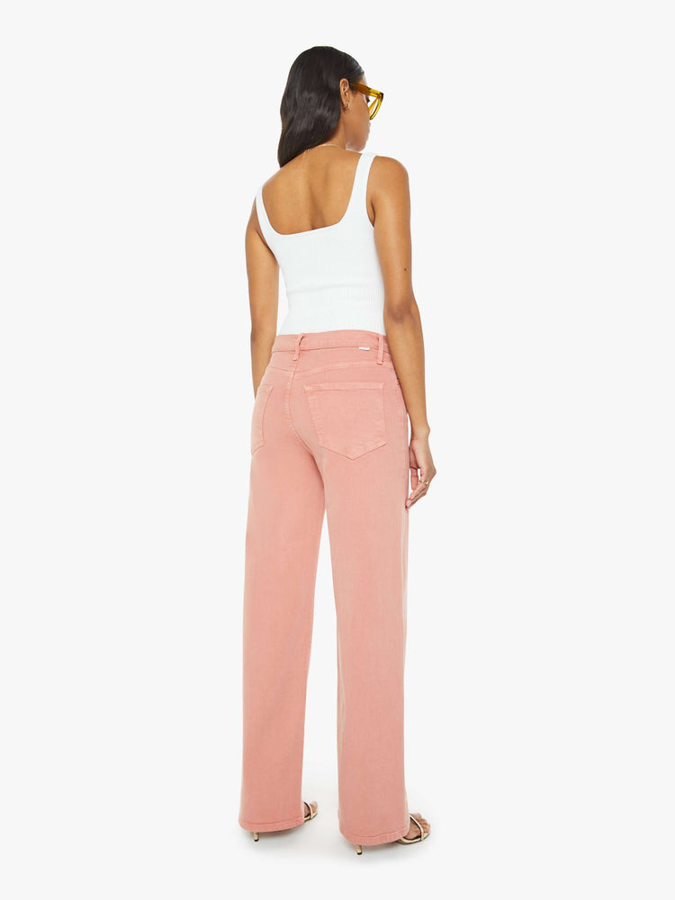 Back view of a woman in light coral pants designed to sit on the hips with a slouchy fit, a loose straight leg and a 32-inch inseam with a clean hem.