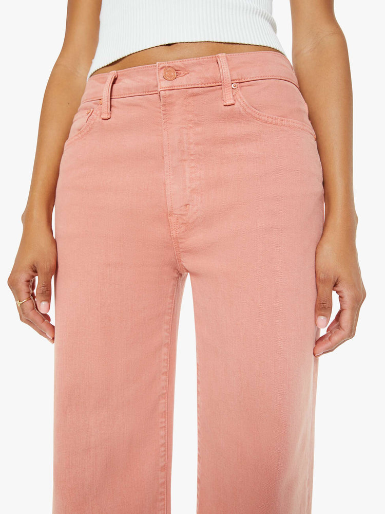 Close up view of a woman in light coral pants designed to sit on the hips with a slouchy fit, a loose straight leg and a 32-inch inseam with a clean hem.