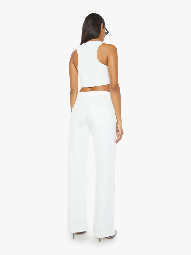 Back view of a woman in a white denim designed to sit on the hips with a slouchy fit, this loose straight leg has a 32-inch inseam with a clean hem. 