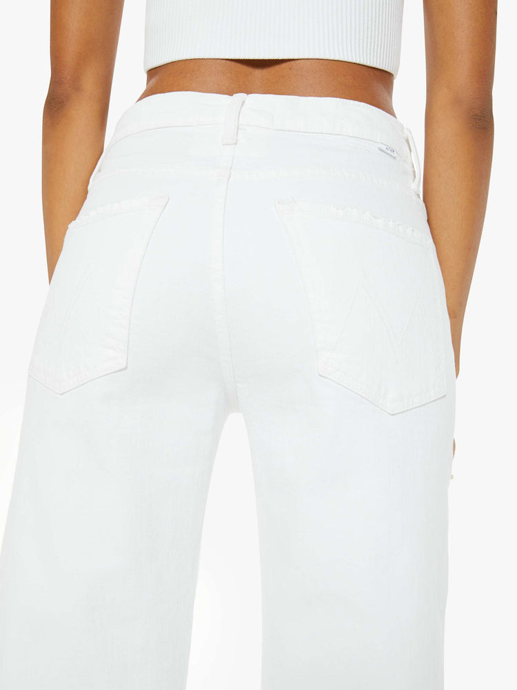 Close back view of a woman in a white denim designed to sit on the hips with a slouchy fit, this loose straight leg has a 32-inch inseam with a clean hem. 