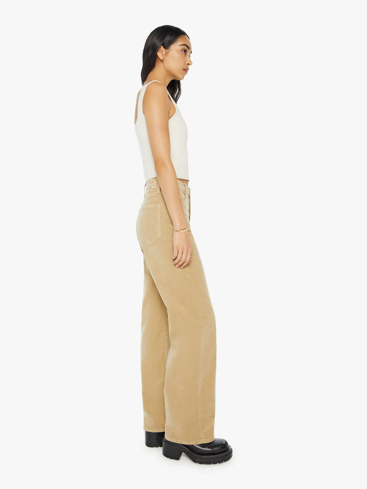 Side view of a woman in a light khaki corduroy loose straight leg jean with a 32-inch inseam.