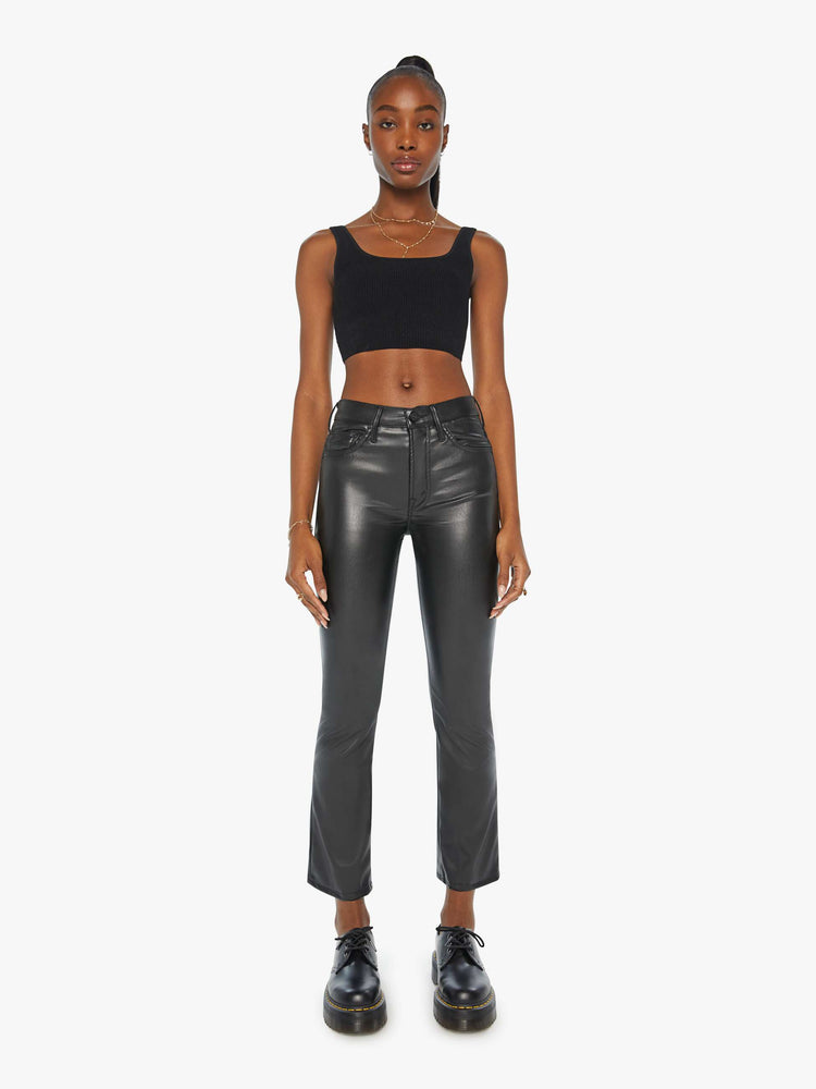 Front view of a woman black faux leather high-rise bootcut has a 28.25-inch inseam and a clean hem.