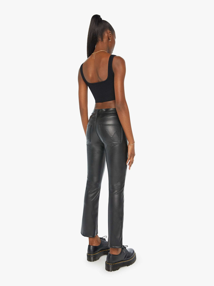 Back view of a woman black faux leather high-rise bootcut has a 28.25-inch inseam and a clean hem.