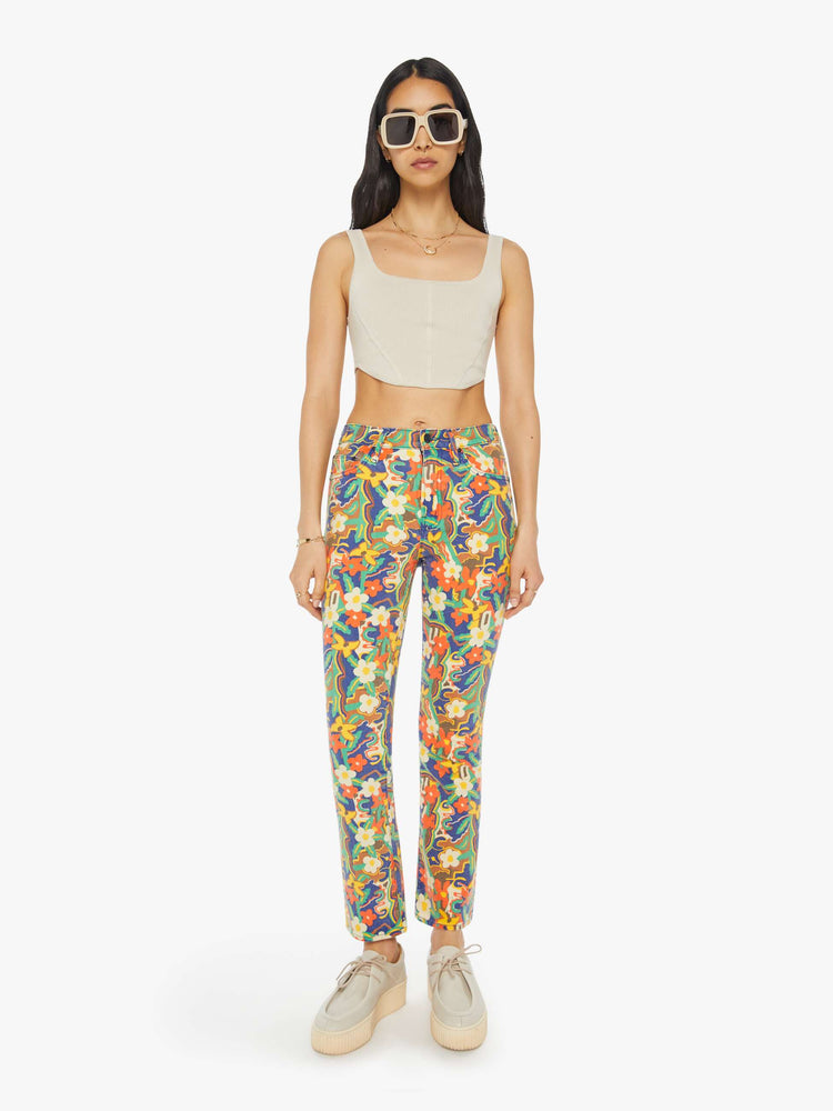 Front view of a woman in colorful floral print high-rise bootcut pants with a clean hem.