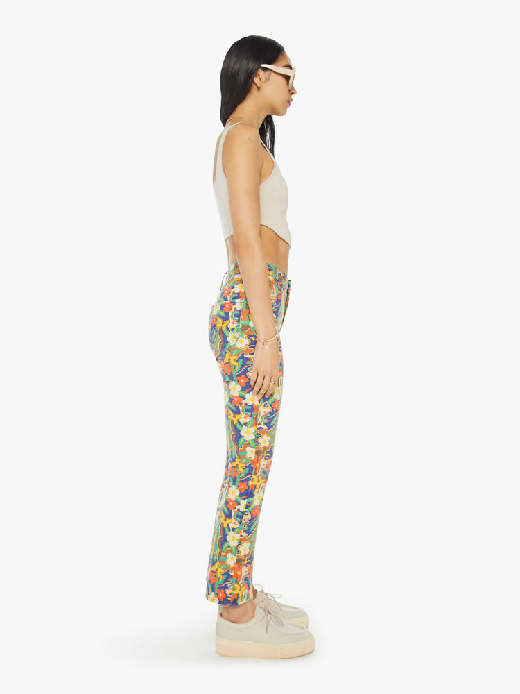 Side view of a woman in colorful floral print high-rise bootcut pants with a clean hem.