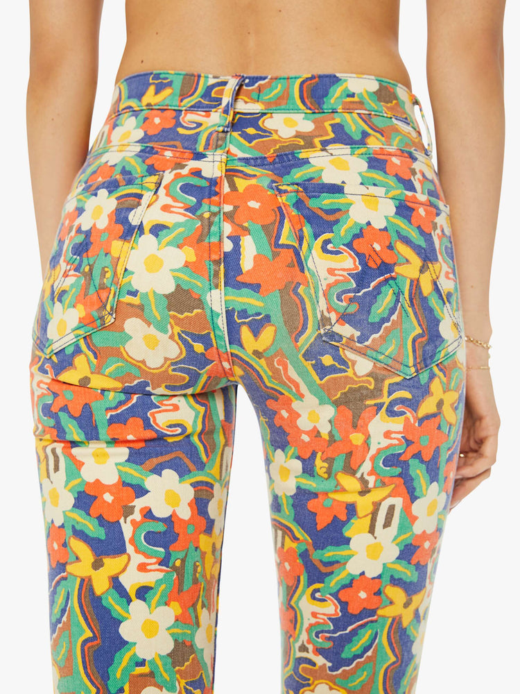 Detailed view of a woman in colorful floral print high-rise bootcut pants with a clean hem.