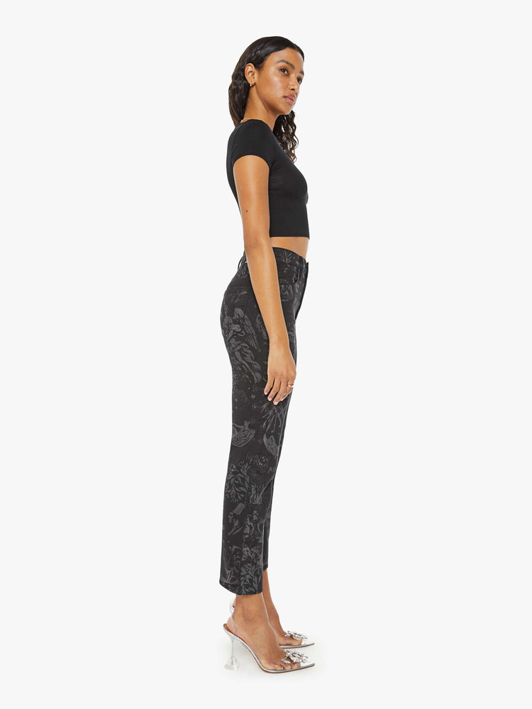 Side view of a woman  high-waisted straight leg with an ankle-length inseam and a clean hem in black with faded grey figures.