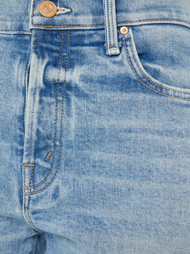 Swatch view of a woman in a light blue button fly jean with a high rise and ankle length hem thats cuffed and frayed.