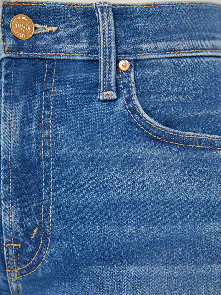 Swatch view of a woman in a mid blue wash mid rise straight leg jean with an ankle length inseam.