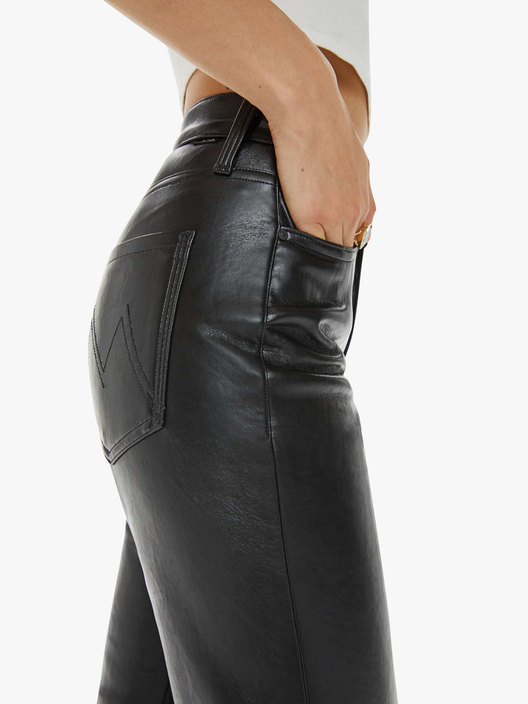 Pocket close up view of a woman in a recycled black leather high waisted straight-leg pants with a 31-inch inseam and a clean hem.