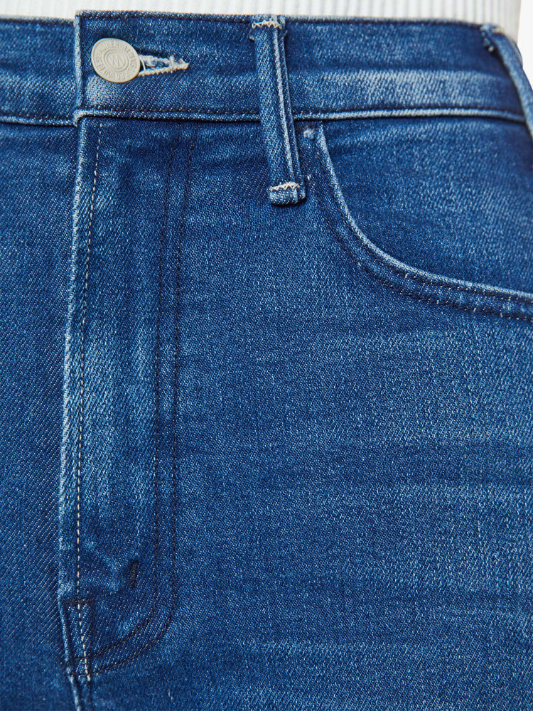 Swatch view of a woman dark blue high-rise bootcut has a 28.25-inch inseam and a frayed hem.