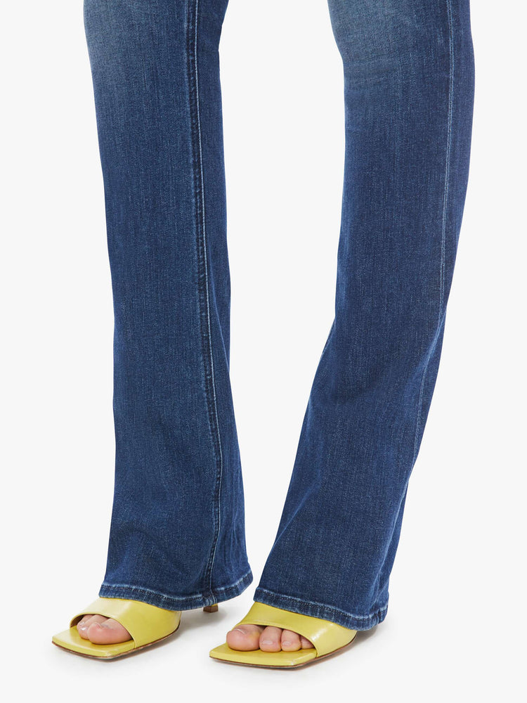 Hem view of a dark blue wash denim skinny flare featuring a high rise.