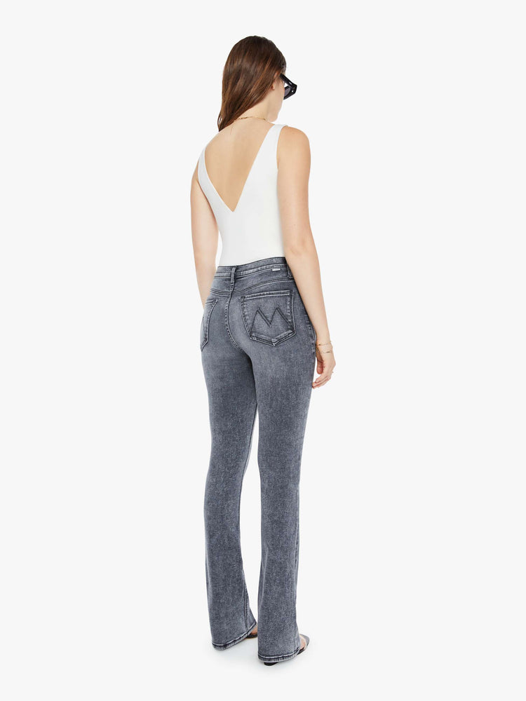 Back view of a womens grey wash flare jean featuring a high rise, and a long clean hem.