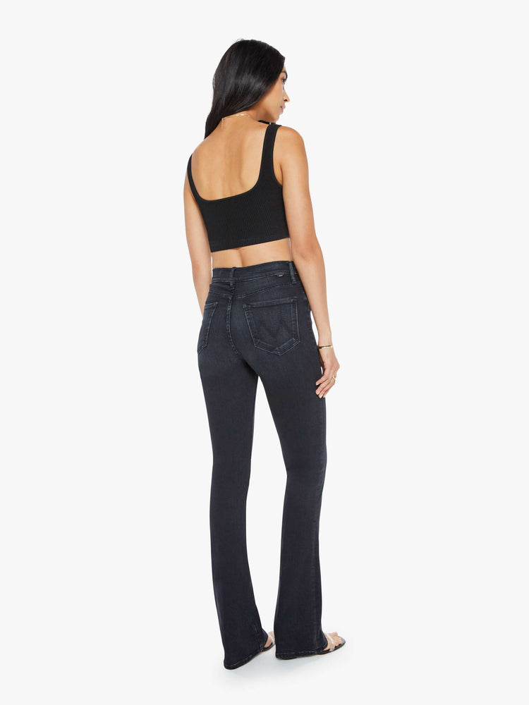 Back view of a womens high rise flare jean featuring a dark black wash and a clean hem.