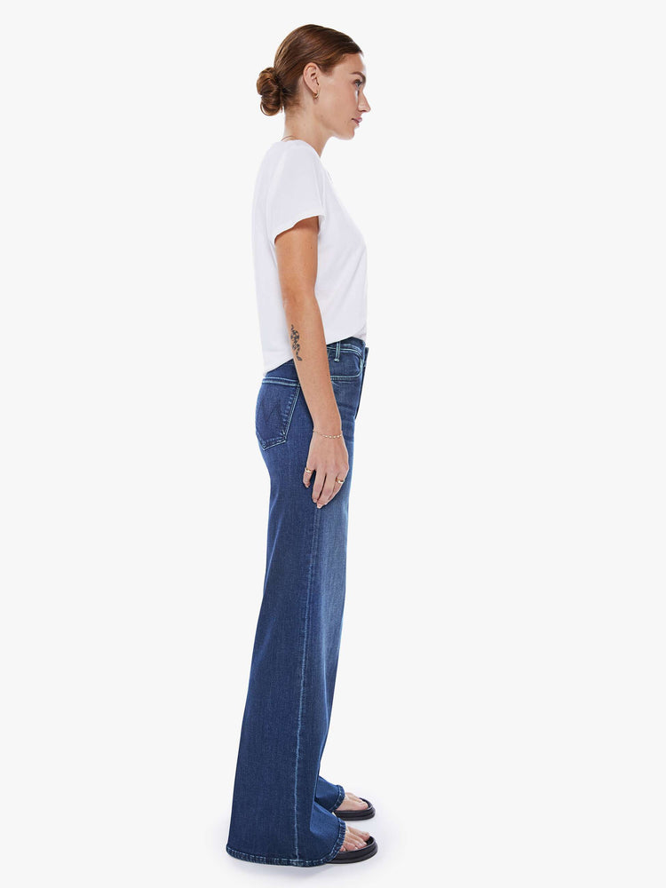 Side view of a woman wide leg jeans with a high rise, 32-inch inseam and a clean hem in a dark blue wash.