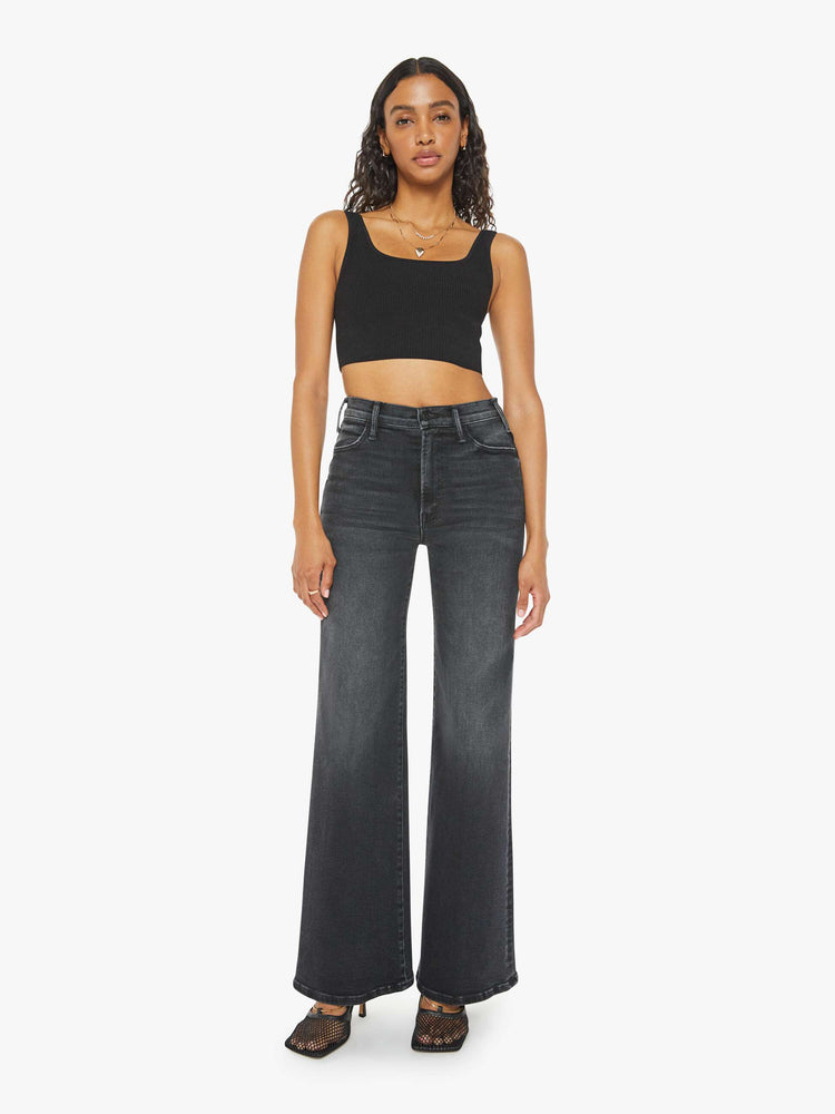 Front view of a woman in a black wash  wide leg jeans with a high rise, 30-inch inseam and a clean hem. 