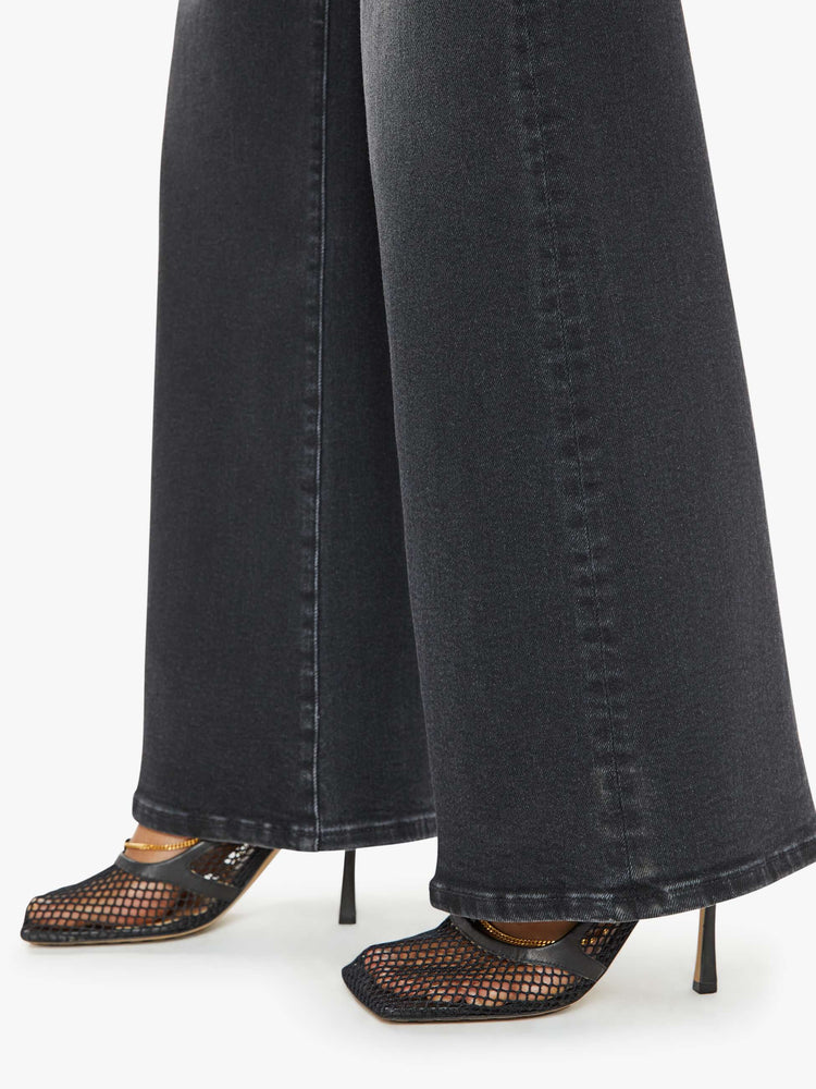 Hem close up view of a woman in a black wash  wide leg jeans with a high rise, 30-inch inseam and a clean hem. 