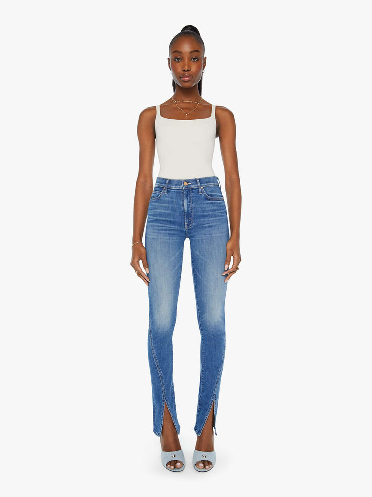 Front view of a woman in a med blue high-rise straight leg jean with a long 34-inch inseam and a split front hem.