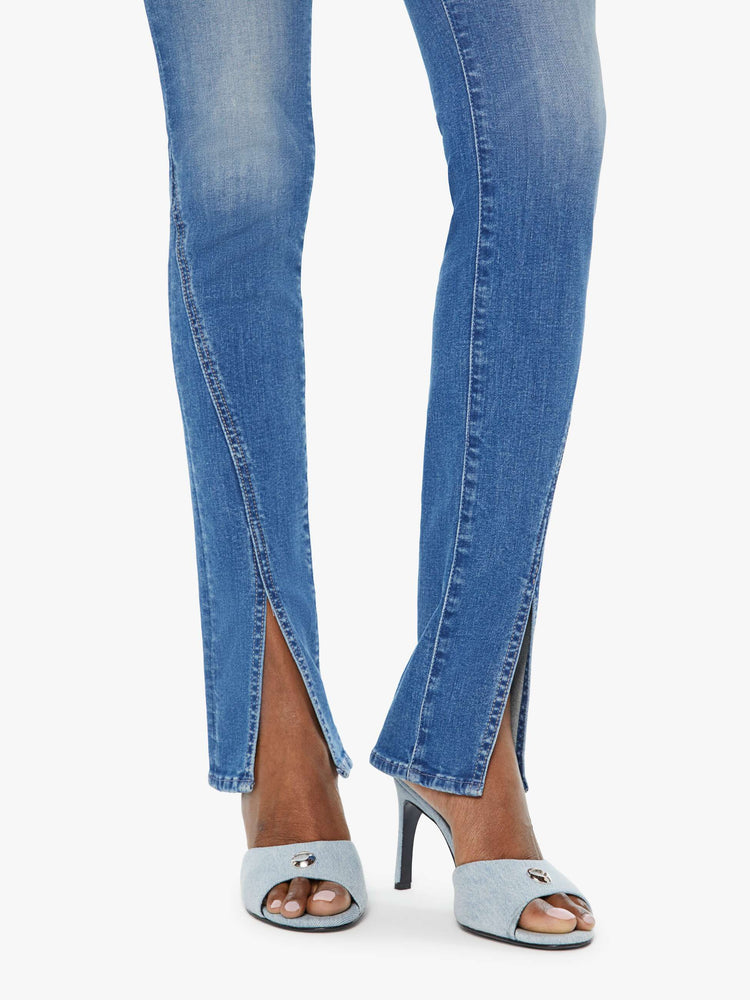 Hem view of a woman in a med blue high-rise straight leg jean with a long 34-inch inseam and a split front hem.