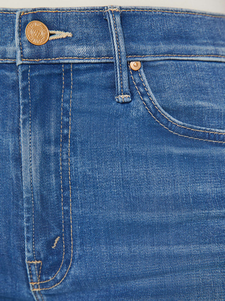 Swatch view of a woman in a med blue high-rise straight leg jean with a long 34-inch inseam and a split front hem.