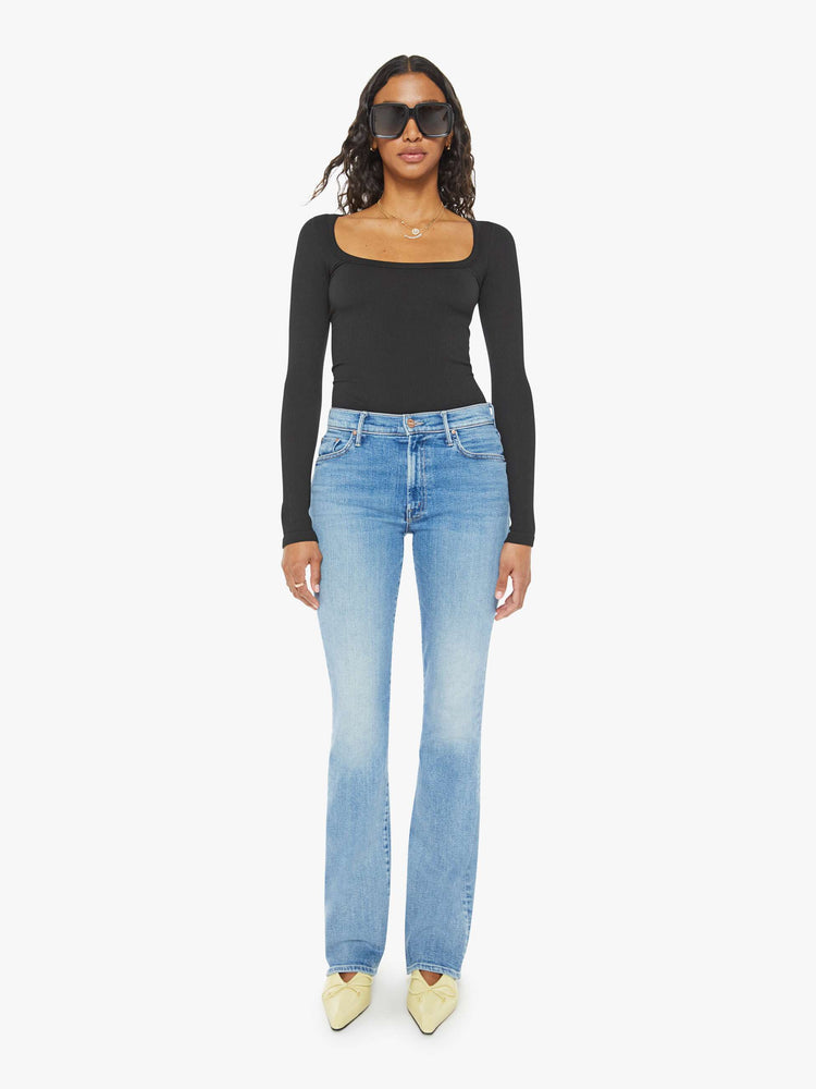 Front view of a woman midblue wash flare jeans with a mid rise and a long 32-inch inseam with a clean hem.