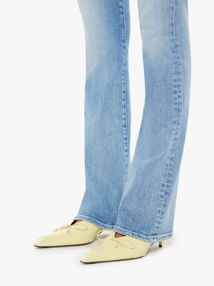 Hem close up view of a woman midblue wash flare jeans with a mid rise and a long 32-inch inseam with a clean hem.