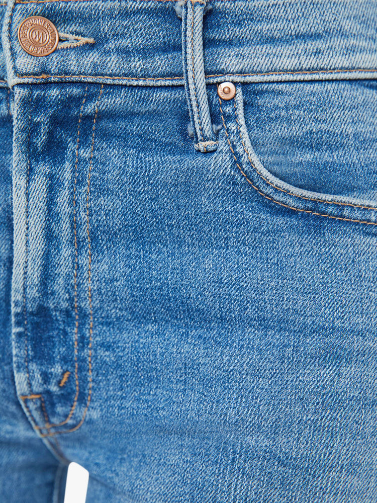 Swatch view of a woman midblue wash flare jeans with a mid rise and a long 32-inch inseam with a clean hem.