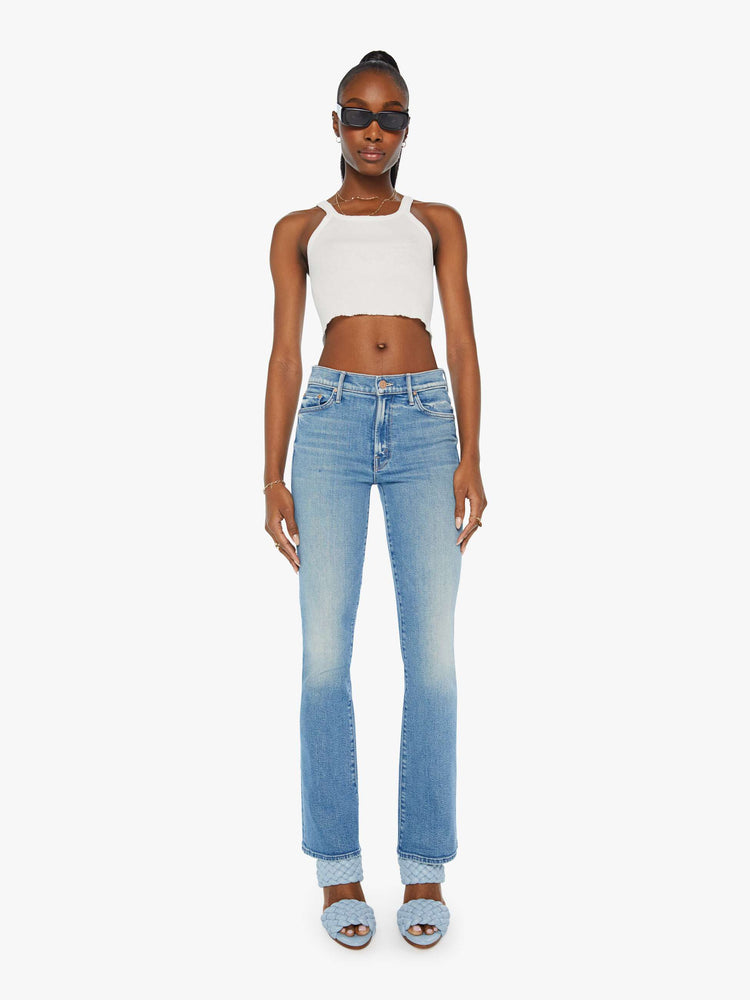 Front view of a woman in mid rise flare jean in a light blue wash. 