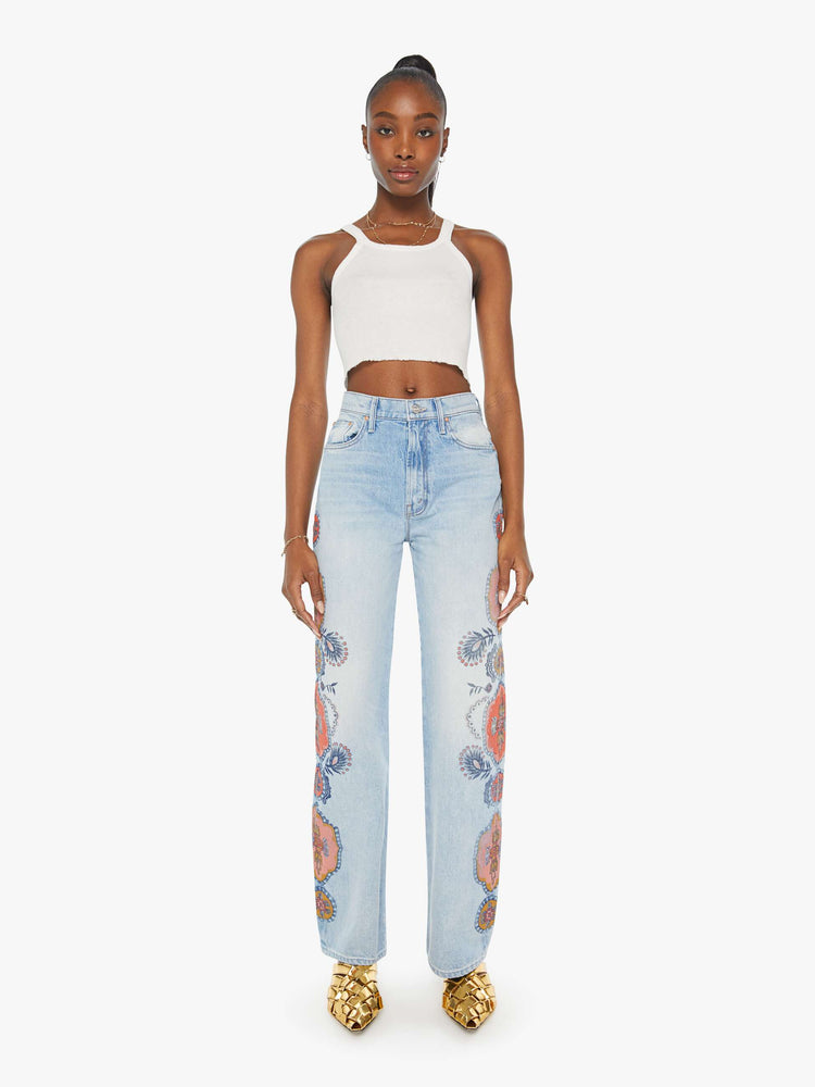 Front view of a high rise wide leg jean in a light blue wash with printed pattern down the side of each leg.