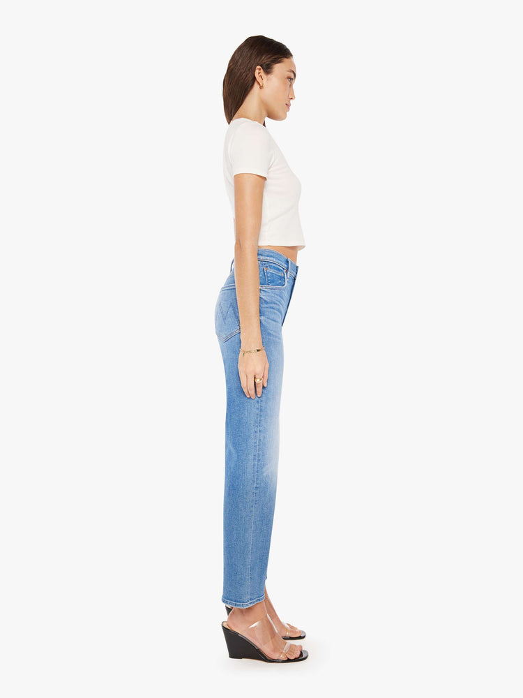 Side view of a woman high-waisted jean with a wide straight leg, zip fly and clean 28.25-inch inseam in a mid blue wash.