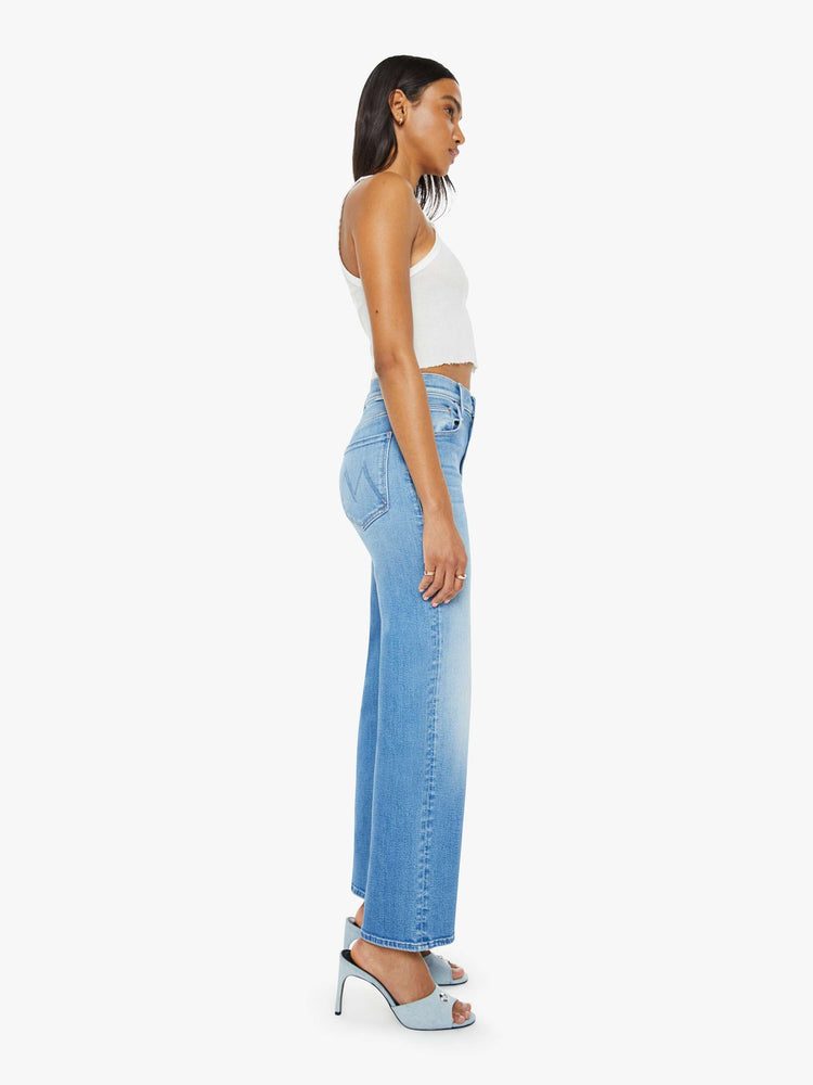 Side  view of a woman medium blue wash high-waisted jeans with a wide straight leg, zip fly and clean 28.25-inch inseam.