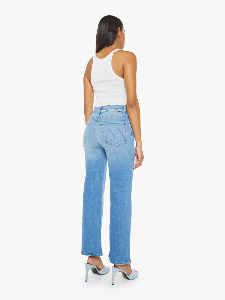 Back  view of a woman medium blue wash high-waisted jeans with a wide straight leg, zip fly and clean 28.25-inch inseam.