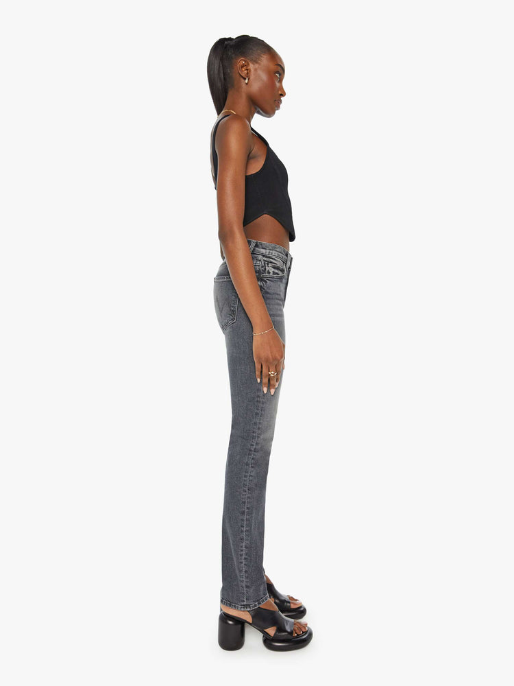 Side view of a woman in mid-rise dark grey straight leg jeans with a clean hem.