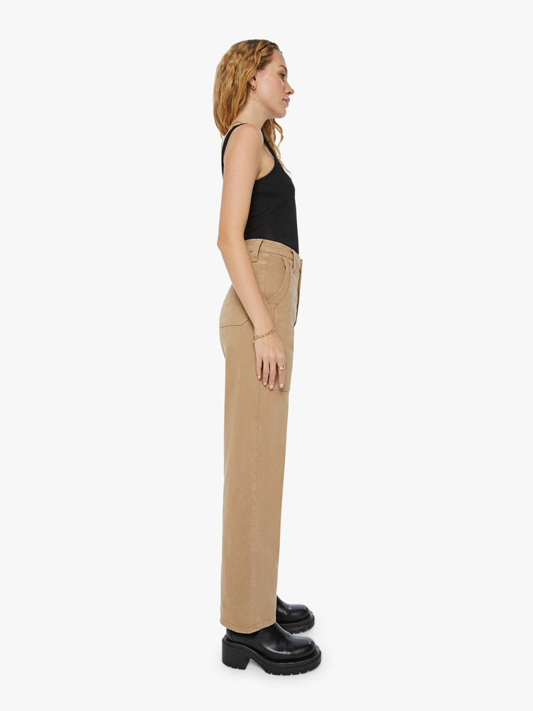 Side view of a woman super high-waisted pants with a wide straight leg, patch pockets and a long 31-inch inseam with a clean hem in a dark khaki.