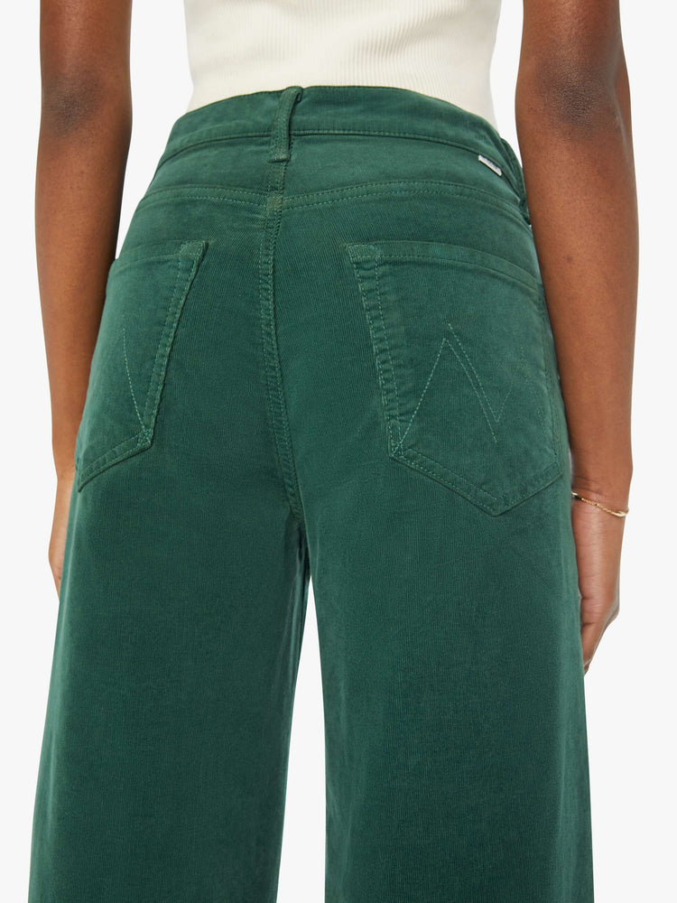 Swatch view of a woman in dark green corduroy wide-leg jeans feature a zip fly, low-set back pockets, high-rise with a slightly dropped crotch and a slouchier fit.