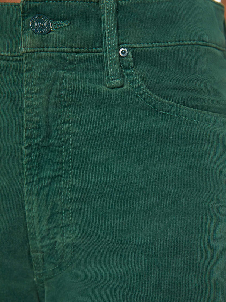 Detailed view of a woman in dark green corduroy wide-leg jeans feature a zip fly, low-set back pockets, high-rise with a slightly dropped crotch and a slouchier fit.